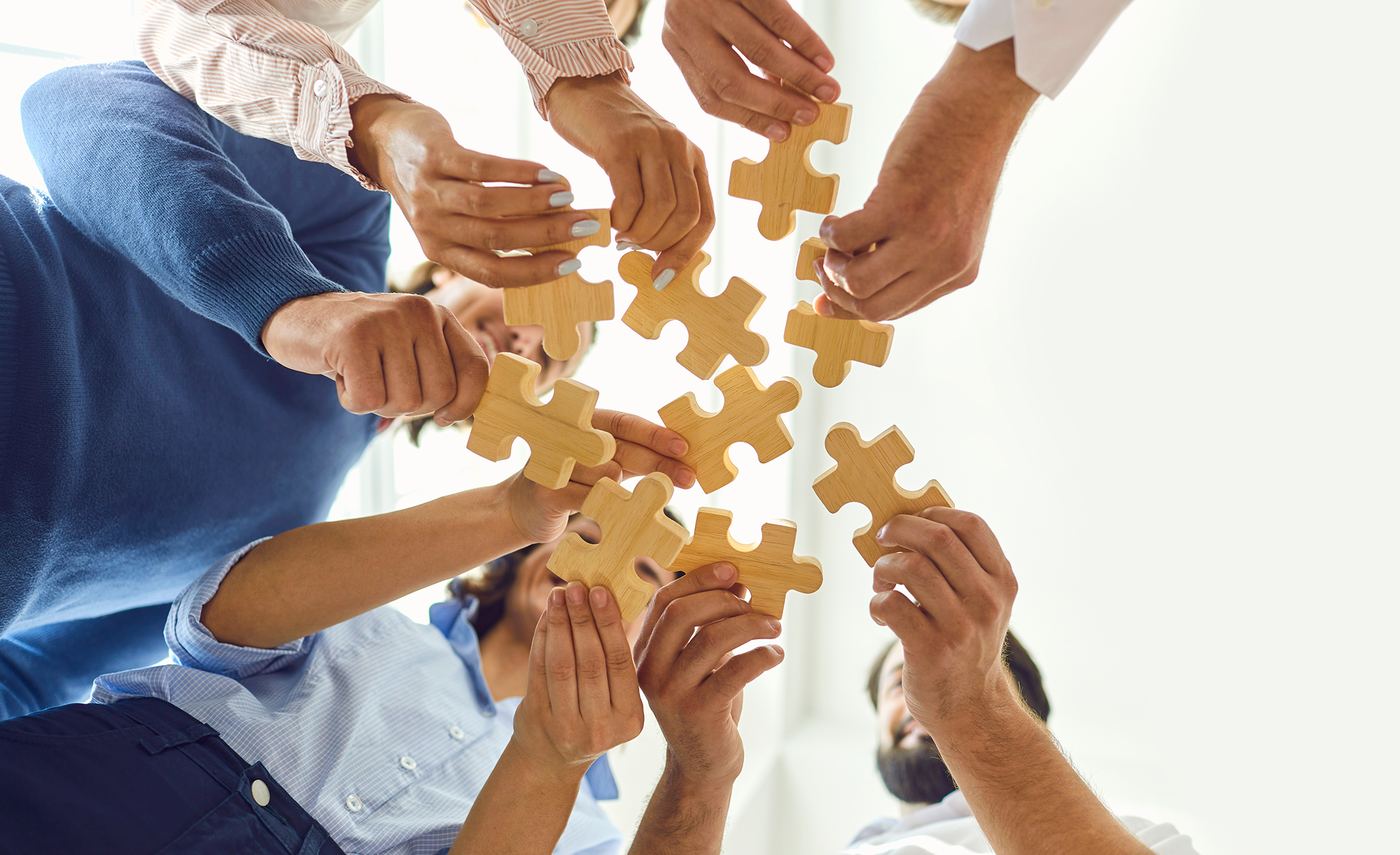 Hands joining puzzle pieces together